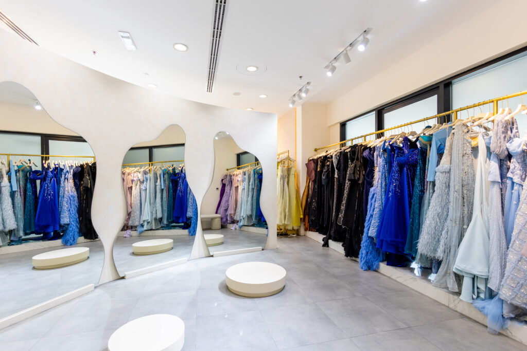 3 curved mirrors and a rail of evening gowns