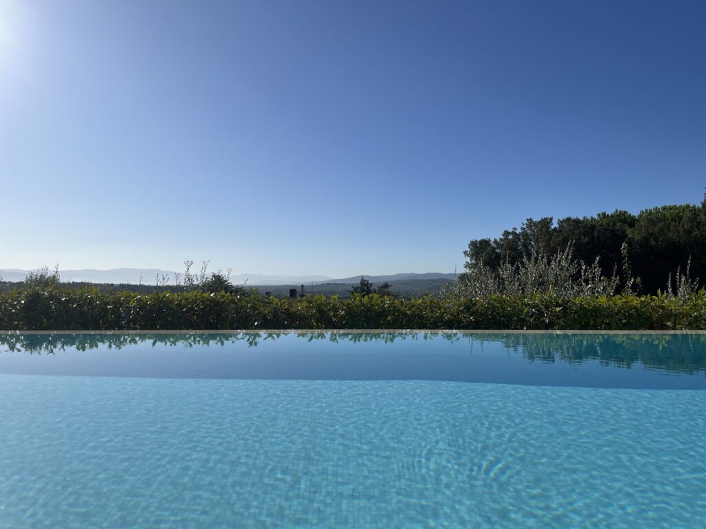 Infinity pool at the edge of the garden, with the Umbrian hills beyond